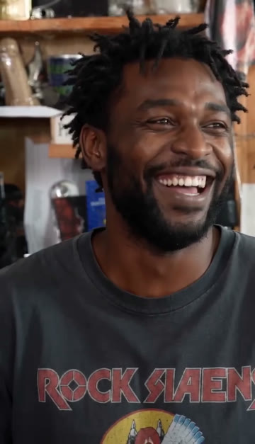 The lead singer laughing in the long close-up of a Tiny Desk AI sample video